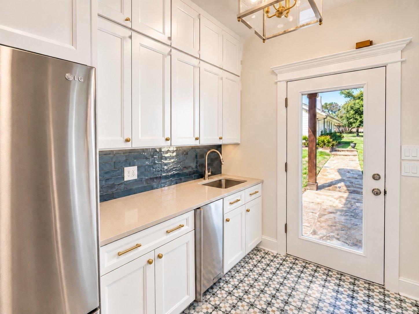 Laundry counter with sink, blue tile backsplash and refrigerator