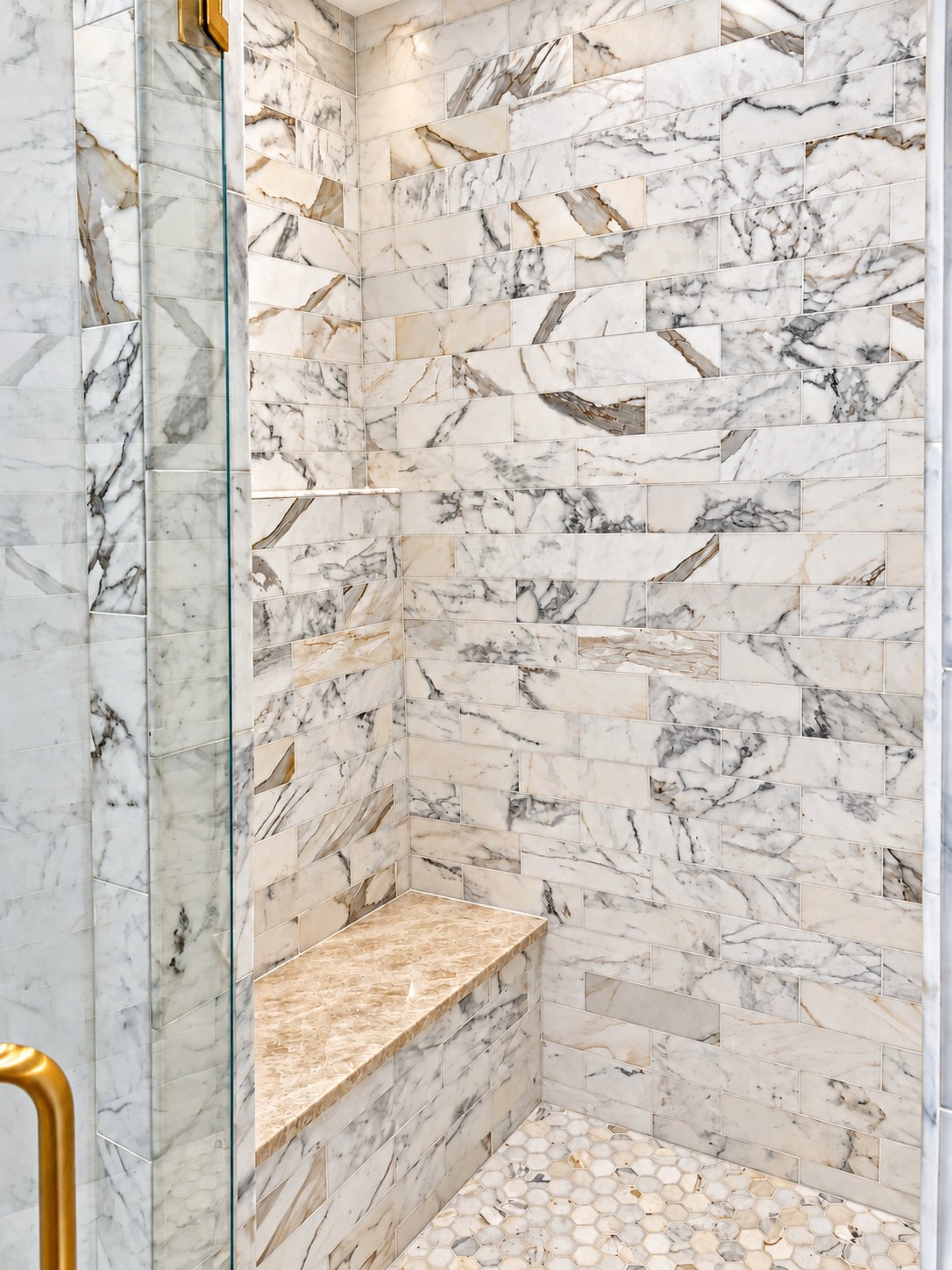 Marble subway tile shower with bench and hex floor