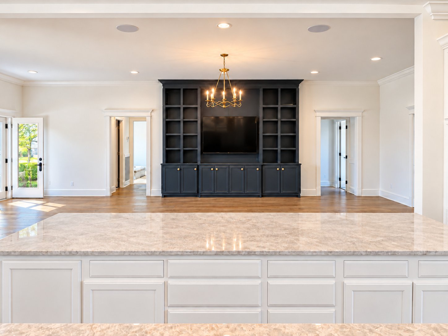 View across the marble kitchen island to the dark media built-in