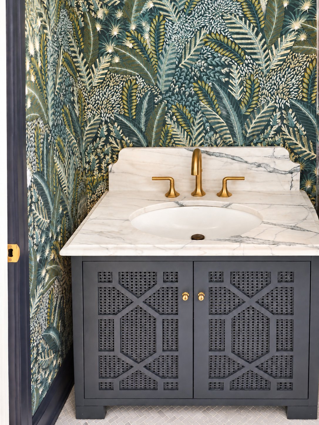 Powder bath with botanical wallpaper, marble vanity and brass faucet
