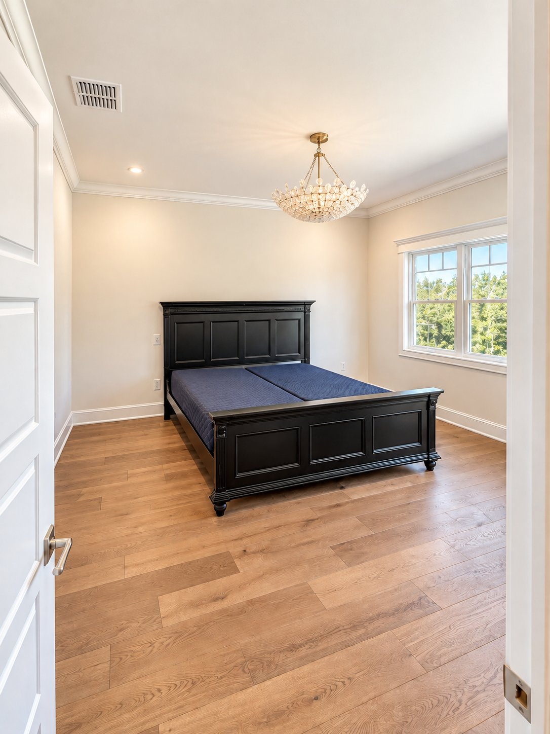 Secondary bedroom with wood floor and chandelier
